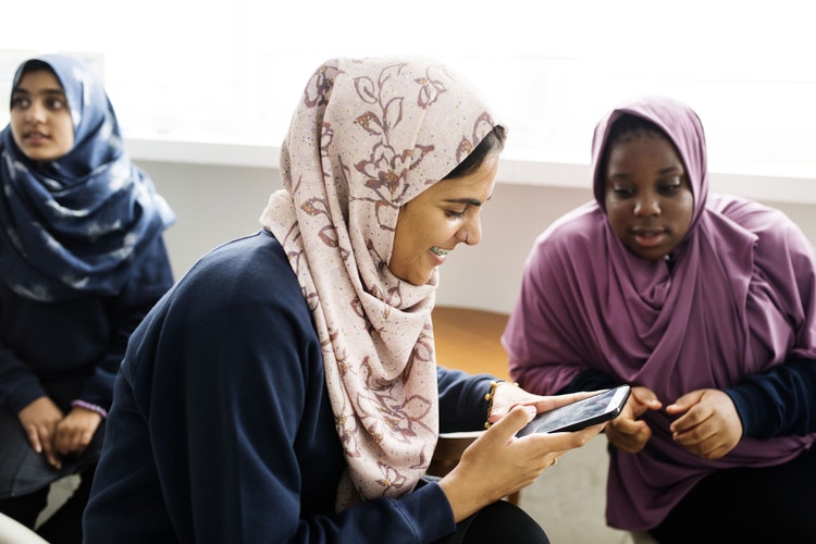 Students smiling while using an educational app